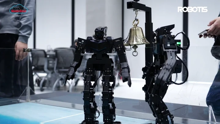Two ROBOTIS ENGINEER humanoids moving their arms during a demonstration